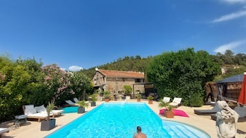 Een seizoensgebonden buitenzwembad en parasols bij het zwembad