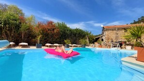 Una piscina al aire libre de temporada, sombrillas, tumbonas