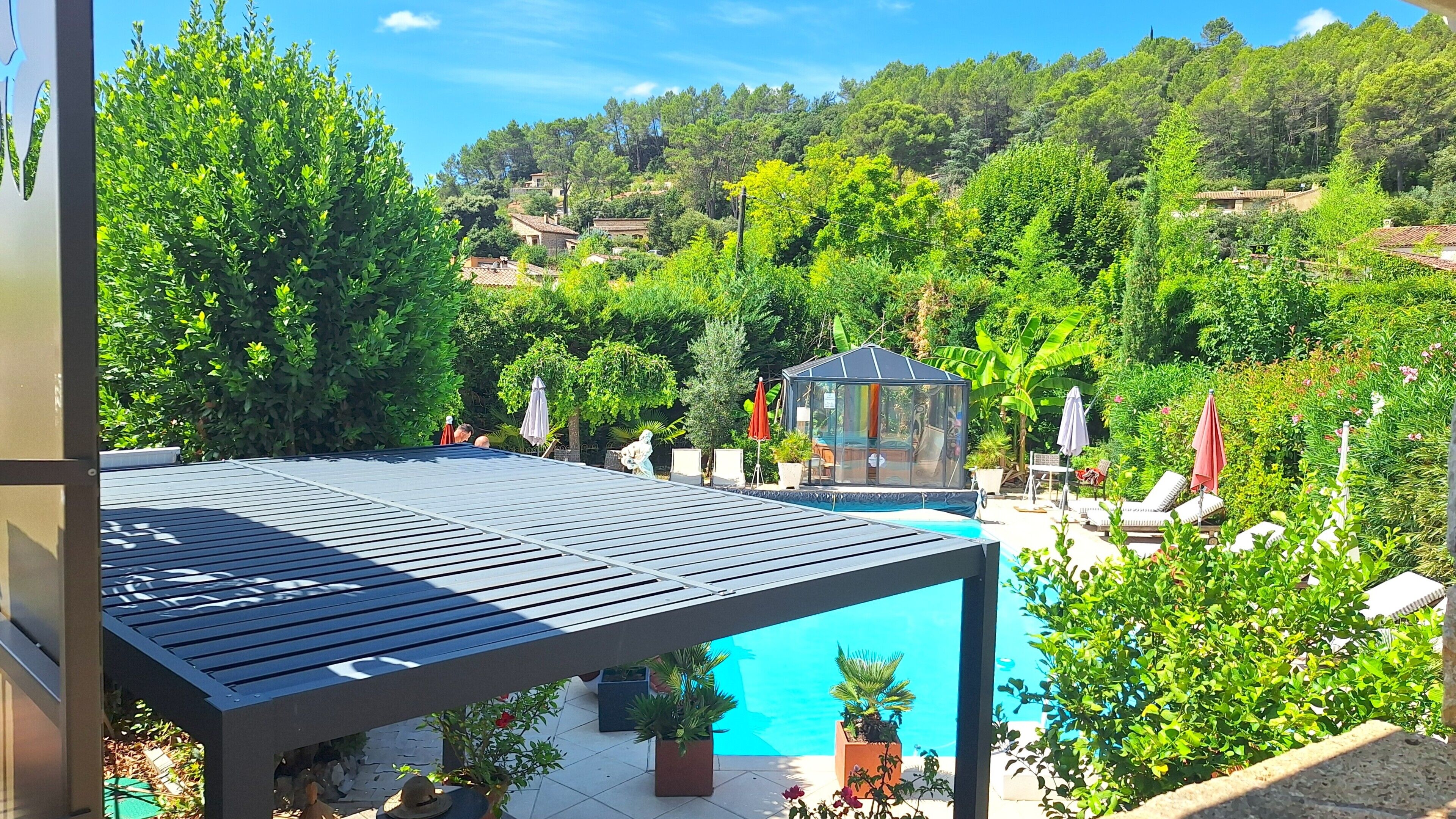 Zona de piscina en la azotea con vistas despejadas a la vegetación y colinas circundantes.