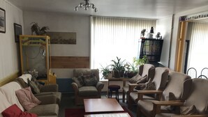 Una sala de estar con un conjunto de sofá, una mesa de centro y diversas plantas en macetas.