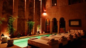 A spa with a pool, multiple massage tables, and potted plants. - Riad Noir d'Ivoire (Marrakech)