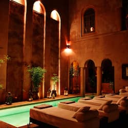 Relax by the serene pool surrounded by arched windows and lush greenery.