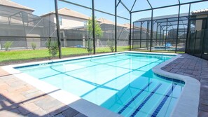 A swimming pool with a clear blue water, surrounded by a brick patio and a glass enclosure. - Grhmyr1465 - Champions Gate Resort - 6 Bed 6 Baths House (Davenport)