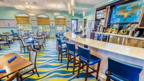 A bar area with a counter, bar stools, and a patterned carpet.