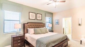 A bedroom with a bed, nightstands, a ceiling fan, and a door. - Grhrfd1469 - Champions Gate Resort - 9 Bed 5 Baths House (Davenport)