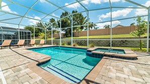 A covered outdoor swimming pool with lounge chairs and a glass enclosure. - Grhmvd1554 - Champions Gate Resort - 5 Bed 4 Baths House (Davenport)