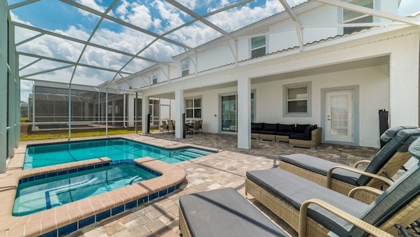 A covered outdoor swimming pool area with lounge chairs and a patio. - Grhhzd9088 - Champions Gate Resort - 9 Bed 5 Baths House (Davenport)