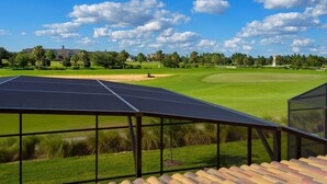 A tennis court with a view of a golf course and a building in the background. - Grhcdw9161 - Champions Gate Resort - 6 Bed 6 Baths House (Davenport)