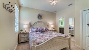 A bedroom with a bed, nightstands, a mirror, and a door. - Grhwgd9165 - Champions Gate Resort - 4 Bed 3 Baths House (Davenport)