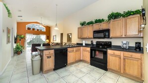 A modern kitchen with wooden cabinets, a black dishwasher, and a microwave.