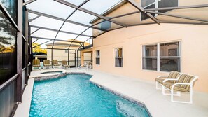 An indoor swimming pool with a glass ceiling, lounge chairs, and a view of the outside. - Grhokc8484 - Emerald Island Resort - 5 Bed 4 Baths House (Kissimmee)