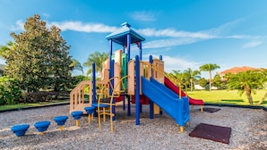 A playground with a slide, climbing structures, and a covered play area.