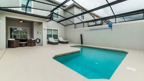 An indoor swimming pool with a glass ceiling, lounge chairs, and a small seating area. - Grhmvd1595 - Champions Gate Resort - 4 Bed 3 Baths Townhouse (Davenport)