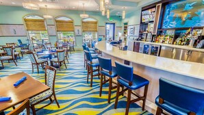 A hotel lobby with a bar area, seating arrangements, and a patterned carpet.