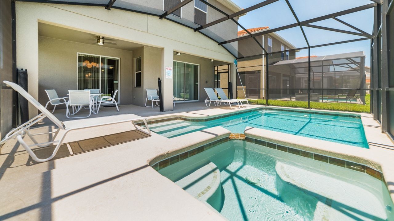 A pool area with lounge chairs and a covered patio.