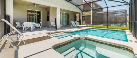 A pool area with lounge chairs and a covered patio.