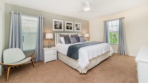A bedroom with a bed, bedside tables, a chair, and a ceiling fan. - Grhbch2953 - Paradise Palms Resort - 6 Bed 5 Baths House (Kissimmee)