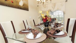 A dining table set for six with placemats, plates, and wine glasses. - Grhbch3043 - Paradise Palms Resort - 4 Bed 3 Baths Townhouse (Kissimmee)