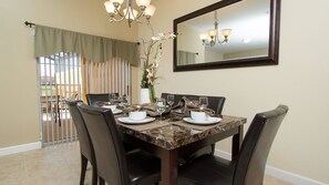 A dining area with a marble table, black chairs, and a chandelier. - Grhcap8851 - Paradise Palms Resort - 4 Bed 3 Baths Townhouse (Kissimmee)