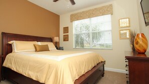 A bedroom with a large bed, a nightstand, a dresser, and a window with blinds. - Grhcap8858 - Paradise Palms Resort - 6 Bed 5 Baths House (Kissimmee)