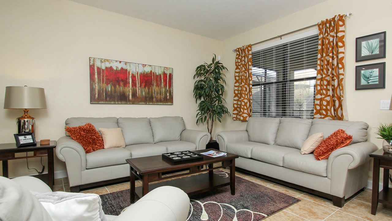 A living room with two sofas, a coffee table, a lamp, and a painting on the wall.