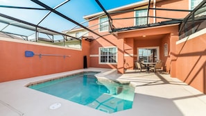 A swimming pool with a glass ceiling, a patio with a table and chairs, and a view of the surrounding buildings. - Grhcup8946 - Paradise Palms Resort - 4 Bed 3 Baths Townhouse (Kissimmee)