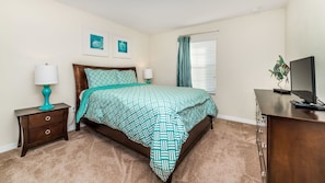 A bedroom with a bed, two bedside tables, a dresser, a television, and artwork on the wall. - Grhcup8946 - Paradise Palms Resort - 4 Bed 3 Baths Townhouse (Kissimmee)