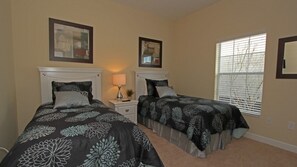A bedroom with two beds, a nightstand, a lamp, and a window with blinds. - Grhcal8967 - Paradise Palms Resort - 5 Bed 4 Baths Townhouse (Kissimmee)