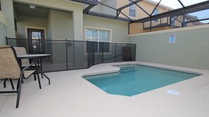 An indoor swimming pool with a glass enclosure, a table, and chairs. - Grhcal8967 - Paradise Palms Resort - 5 Bed 4 Baths Townhouse (Kissimmee)