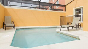 Una piscina interior con dos sillas de descanso y techo de vidrio.