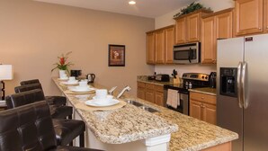 A modern kitchen with granite countertops, stainless steel appliances, and wooden cabinets.