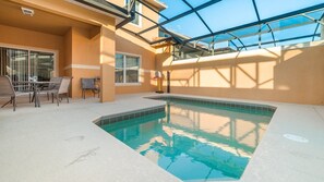 An indoor swimming pool with a glass ceiling, a sunlit patio area with chairs, and a view of the sky. - Grhcat8968 - Paradise Palms Resort - 4 Bed 3 Baths Townhouse (Kissimmee)