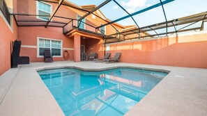 An indoor swimming pool with clear blue water, surrounded by a covered patio area with lounge chairs and a small seating area. - Grhcup8968 - Paradise Palms Resort - 4 Bed 3 Baths Townhouse (Kissimmee)