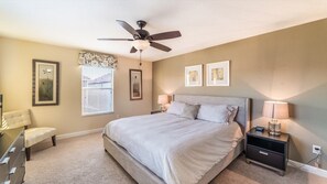 A bedroom with a bed, bedside tables, a ceiling fan, and framed artwork on the walls. - Grhbis8974 - Paradise Palms Resort - 5 Bed 5 Baths House (Kissimmee)