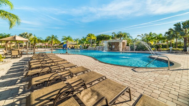 Zona de piscina con sillones de descanso y una fuente de agua.
