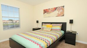 A bedroom with a bed, two bedside tables, a window, and a wall-mounted artwork. - Grhbch3069 - Paradise Palms Resort - 4 Bed 3 Baths Townhouse (Kissimmee)