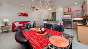 A modern kitchen with a stainless steel refrigerator, wooden cabinets, and a granite countertop. - Enjoy Orlando With Us - Reunion Resort - Feature Packed Spacious 3 Beds 2 Baths Townhome - 6 Miles To Disney (Kissimmee)