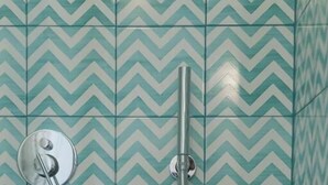 Une douche avec un mur carrelé orné d’un motif en chevrons.