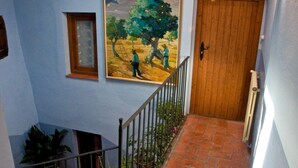 A staircase with a wooden door and a painting of two figures.