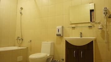 A bathroom with a toilet, sink, and shower.