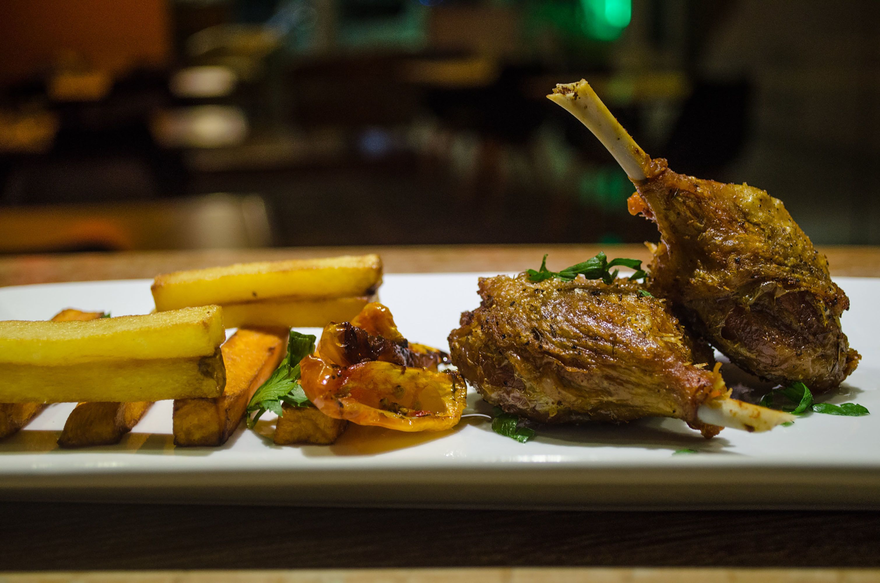 A plate of food with roasted meat, potatoes, and vegetables.