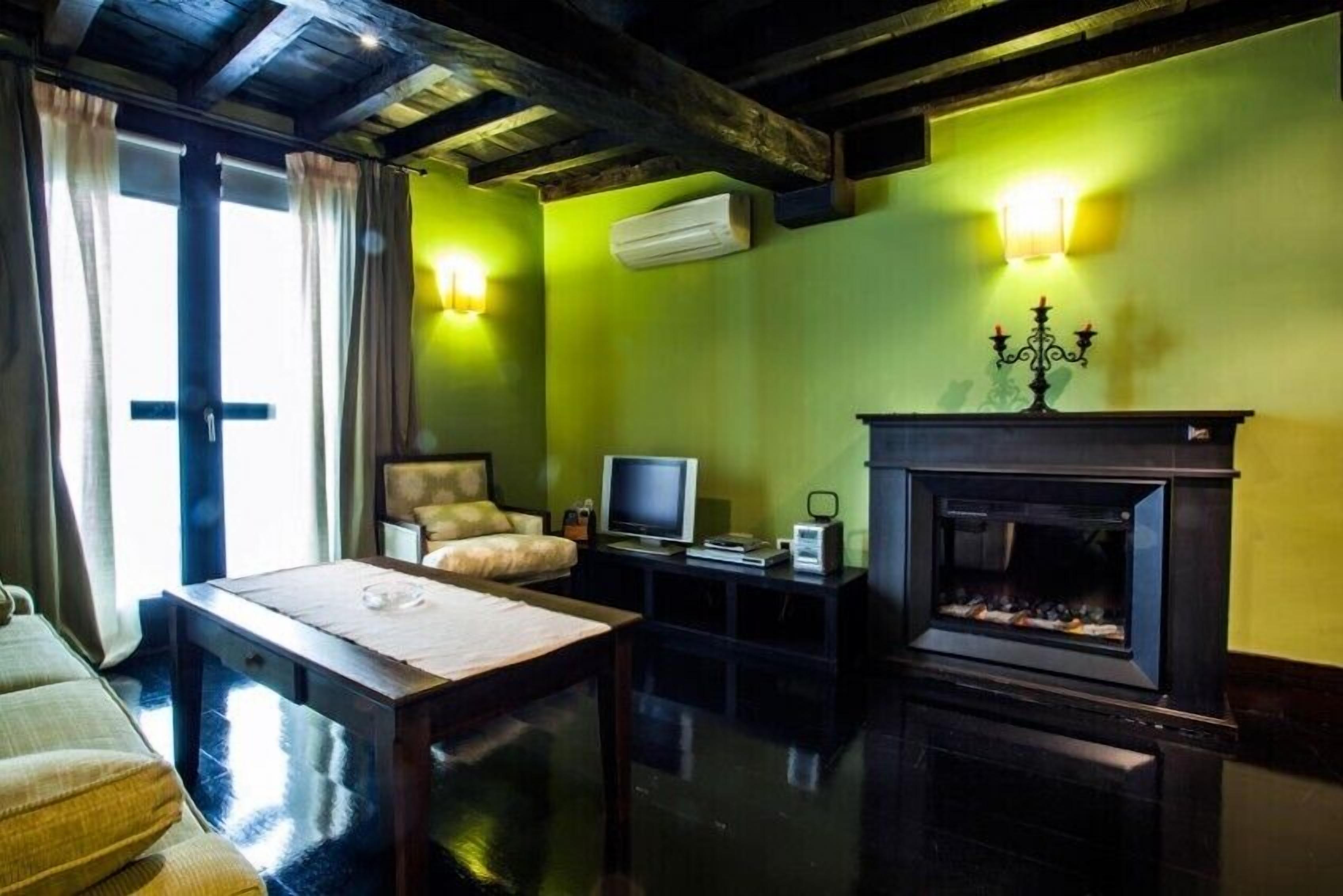 Una sala de estar acogedora con chimenea, televisor y un sofá cómodo.