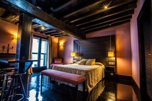 Ein Schlafzimmer mit Bett, Sitzbank und zwei Wandlampen.