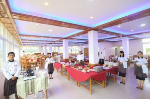 Un amplio comedor con múltiples mesas, sillas y una variedad de platos servidos.