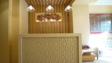 Uma área de recepção com teto de ripas de madeira, painéis decorativos e um painel com padrão.