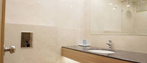 A modern bathroom with a toilet, sink, mirror, and towel rack.