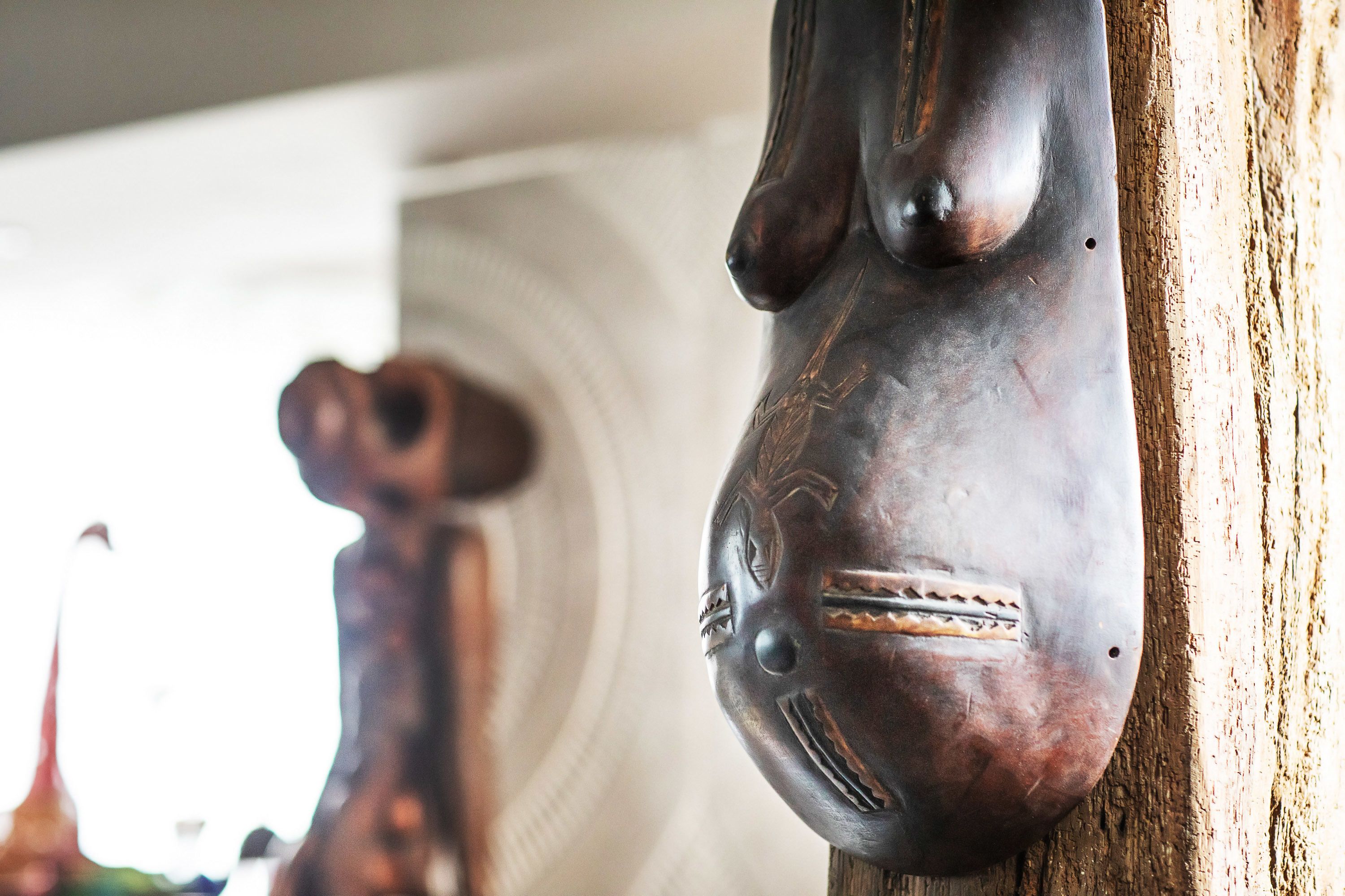 A close-up of a wooden sculpture with a carved face, possibly a decorative item.
