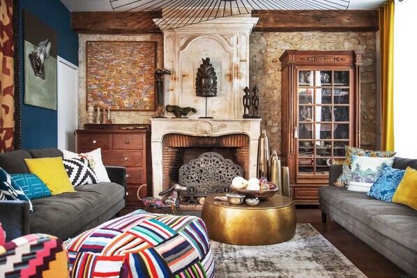 A cozy living room with a fireplace, two sofas, a coffee table, and a bookshelf. - La Bellême Bleue (Belleme)