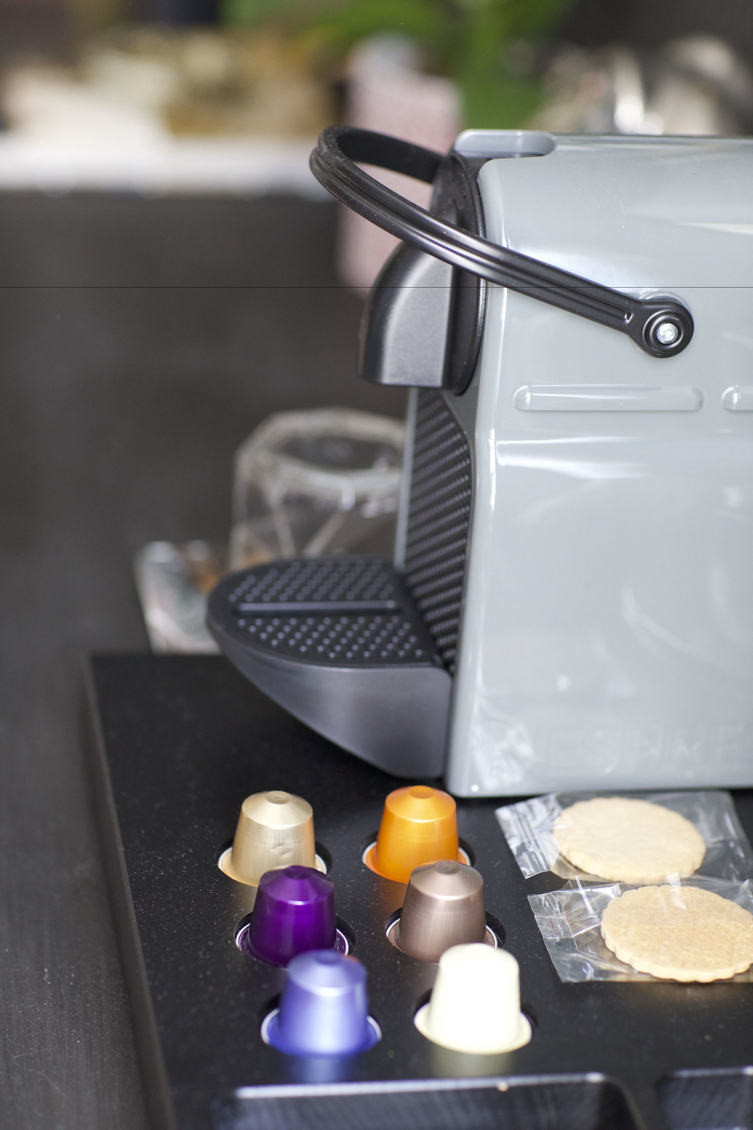 Máquina de café com vários botões e uma bandeja com duas chávenas.