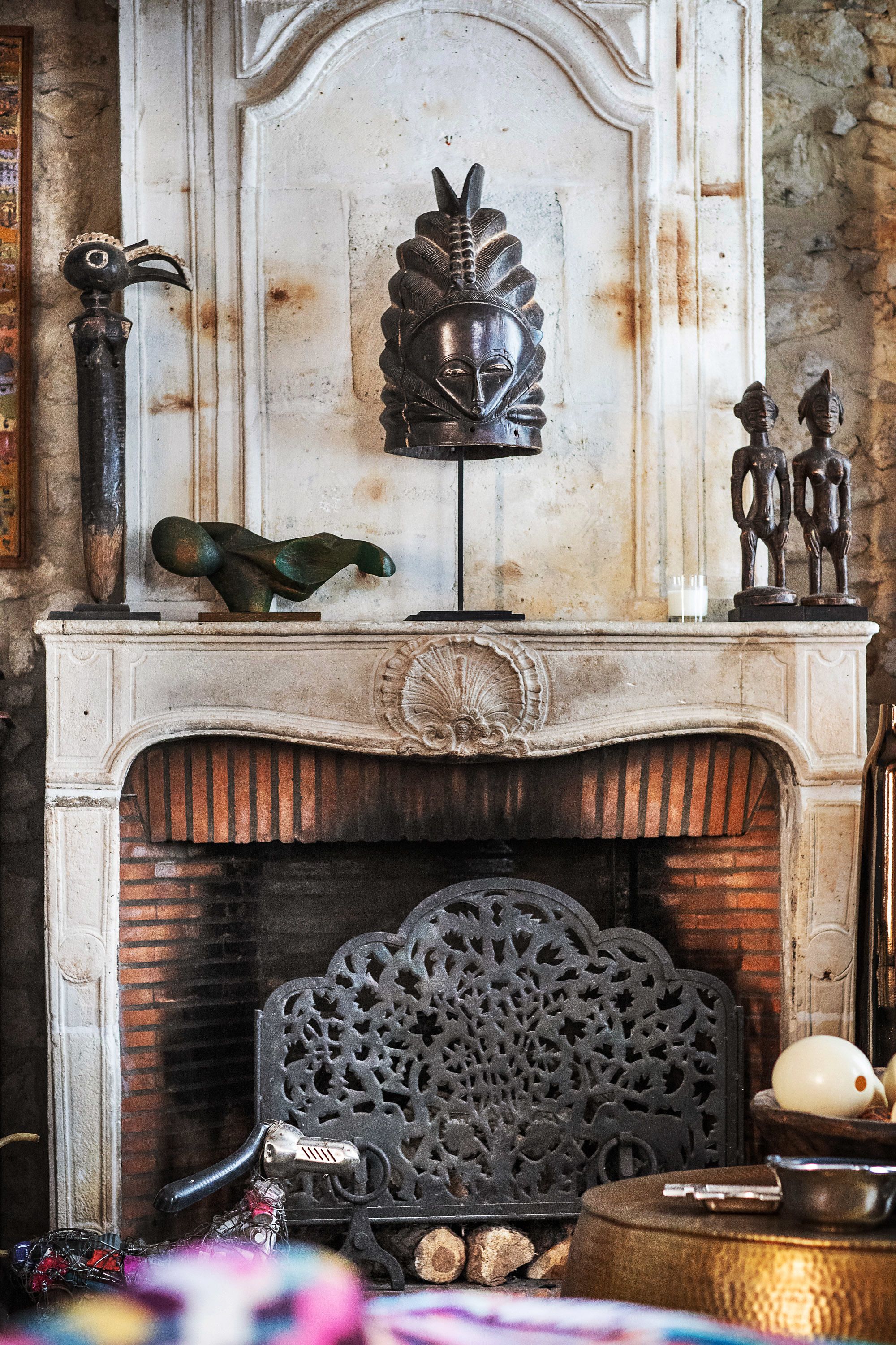 A fireplace with ornate carvings and a decorative metal sculpture.